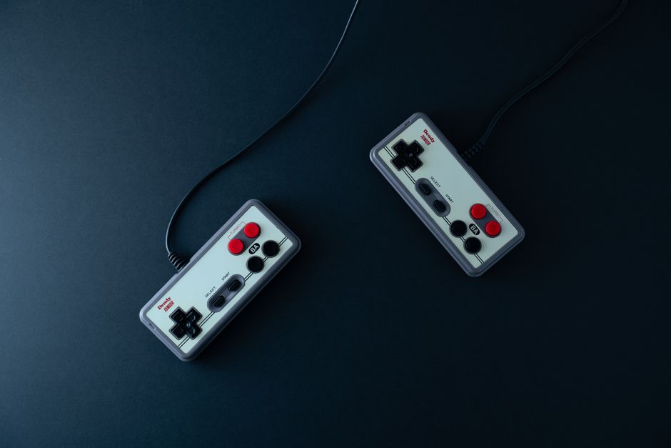 Top view of two retro video game controllers on a dark background (Image Credit: Эдуард Галеев - Pexels)